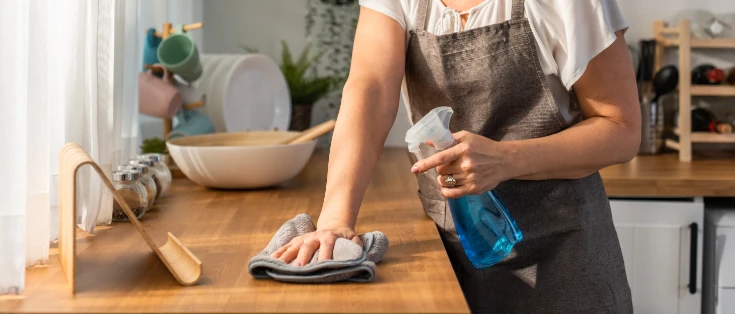 Femme effectuant le nettoyage d’une cuisine chez un particulier en Suisse