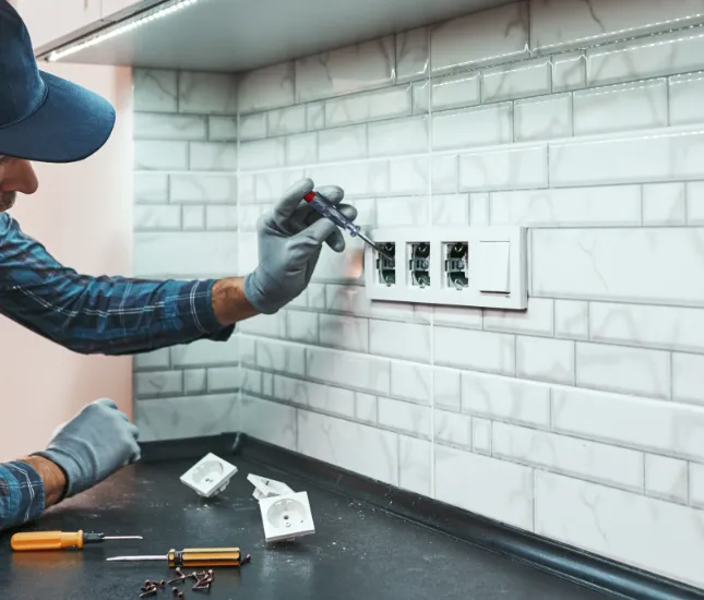 Électricien installant prise triphasée